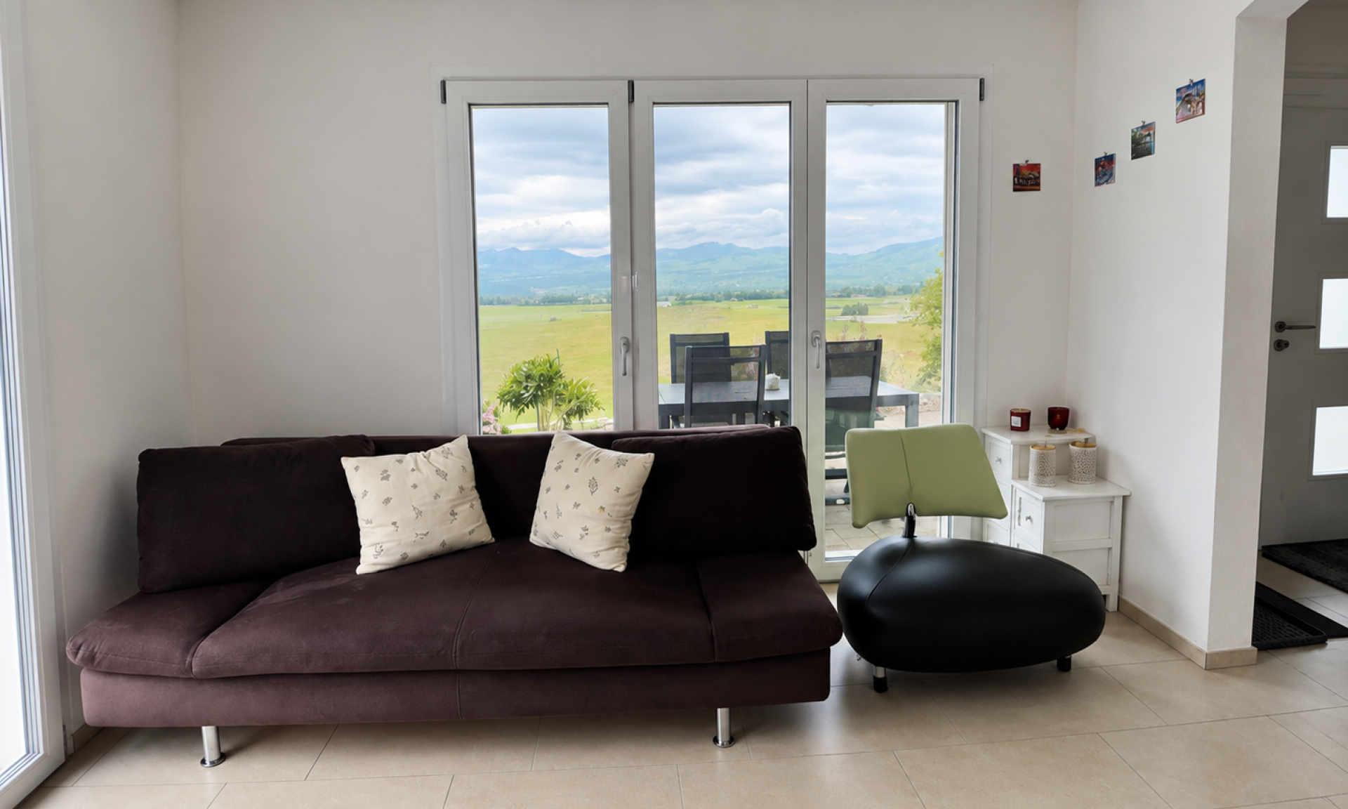 Wohnbereich der Ferienwohnung Luxenweid mit Sofa und Blick auf die Voralpen